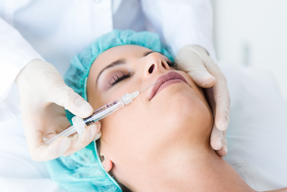 odontoiatra effettua iniezione alle labbra della paziente