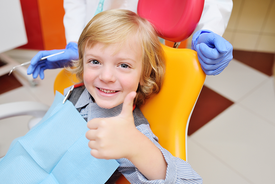 bambino dal dentista con pollice alzato