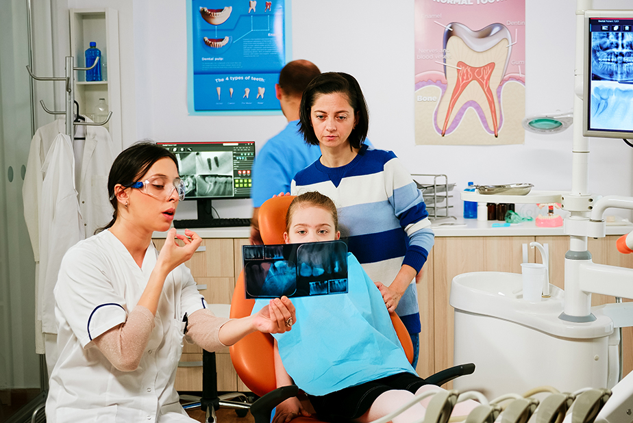 bambino con genitore sulla poltrona del dentista